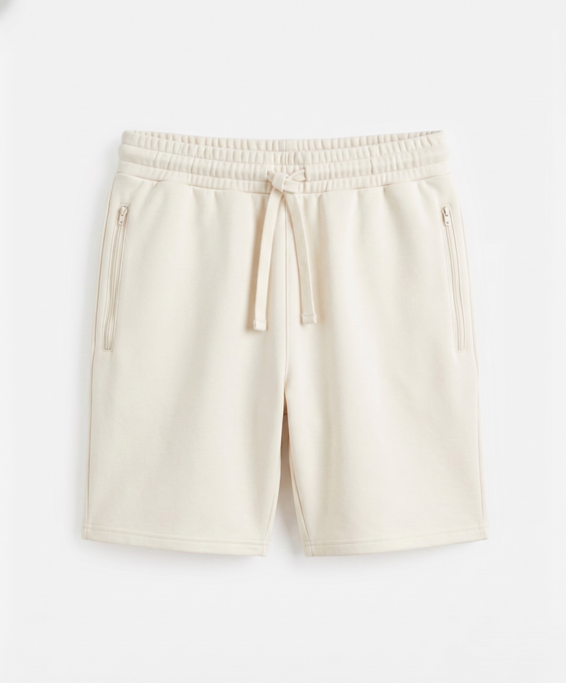Light beige unisex shorts made of 100% cotton french terry fabric, featuring an elastic waistband and pockets.